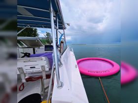 A view from the boat showcasing a vibrant pink floating mat in the water, perfect for fun and relaxation during a day on the water.
