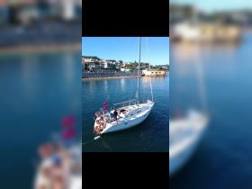 A lively group enjoys a sailing adventure on a yacht, celebrating together in the sun — perfect for memorable outings on the water.