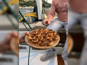 A selection of delicious pastries served on a wooden platter aboard a boat, perfect for enjoying snacks while cruising.