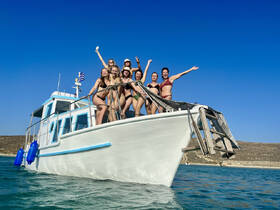 A lively group of friends celebrates aboard a boat, enjoying the sun and water — perfect for summer adventures and memorable outings.