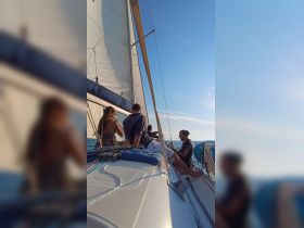 A group of friends enjoys a sunny sailing experience on the open ocean, capturing the essence of adventure and camaraderie on the water.