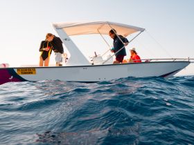 A group of friends enjoys a day on the water aboard a boat, showcasing the fun and adventure of boating activities.