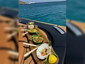 A beautifully arranged platter of gourmet seafood and dips on a boat deck, perfect for enjoying a luxurious day on the water.