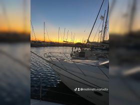 A serene sunset view of a boat docked at the marina, showcasing the tranquil waters and surrounding masts — perfect for evening reflections and peaceful moments by the sea.