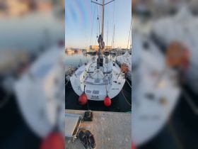 A serene view of a docked Elan yacht, showcasing its sleek design and tranquil marina setting, perfect for sailing enthusiasts.