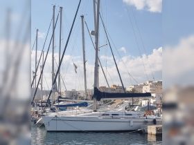 A beautiful sailboat docked in a marina, surrounded by other vessels under a clear blue sky — perfect for sailing enthusiasts and boat lovers.