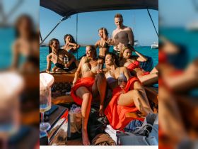 A lively group of friends enjoys a fun day on the water, celebrating with cocktails aboard a stylish boat — perfect for summer parties and unforgettable memories.