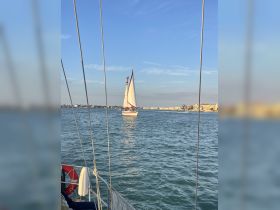 A picturesque view of a sailboat underway, showcasing the beauty of sailing against a scenic backdrop. Perfect for those looking to enjoy a day on the water.
