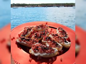 A vibrant platter of delicious appetizers featuring creamy toppings and diced ingredients, perfect for enjoying on a boat while taking in the scenic waterfront views.