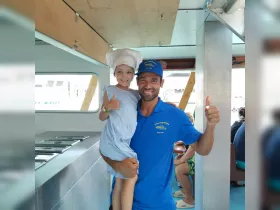 A joyful moment captured inside a boat's cabin, featuring a smiling child and an adult, both giving thumbs up — perfect for family-friendly boating experiences.