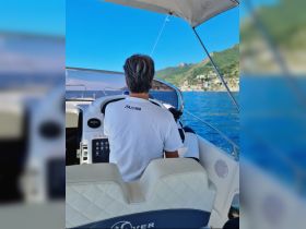 A view from the helm of a boat, showcasing the captain steering while enjoying the scenic coastline. Perfect for those looking to experience the thrill of boating.