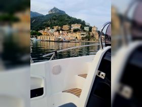 A picturesque view of a charming coastal town reflected in calm waters, seen from the deck of a boat — an ideal setting for exploring beautiful harbors.
