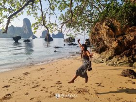 A joyful moment captured on a beach swing, with stunning island scenery in the background — perfect for showcasing fun beach activities and tropical getaways.