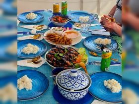 A beautifully arranged dining table on a boat featuring a variety of seafood dishes and drinks, perfect for enjoying a meal while cruising on the water.