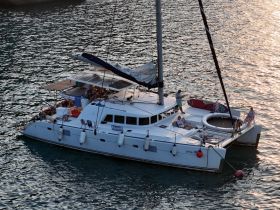 A lively group enjoys a relaxing evening on a catamaran, capturing the essence of sunset cruising with friends.