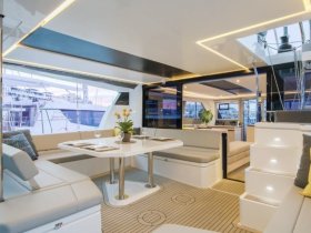 A beautifully designed interior of a yacht featuring a spacious dining area and comfortable seating, perfect for relaxing and entertaining on the water.