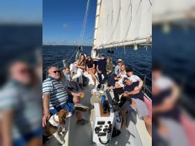A lively group enjoys a sailing adventure, sharing drinks and laughter on deck — perfect for family gatherings or celebrations on the water.