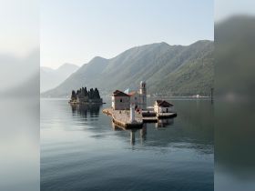A stunning view of serene islands and mountains reflecting in calm waters, showcasing the picturesque beauty of the coastline.
