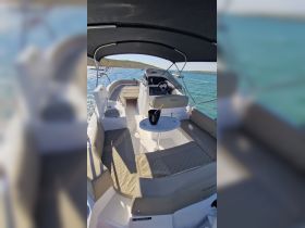 A stylish interior view of a boat showcasing comfortable seating and a helm, perfect for relaxing and enjoying the water.