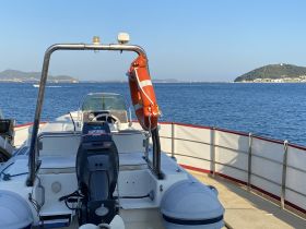 A clear view of a speedboat's exterior, showcasing its hull and engine against a serene water backdrop, perfect for boating enthusiasts.