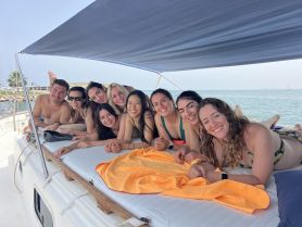 A joyful group of friends relaxes on the deck of a boat, enjoying their time together under the sun — perfect for memorable outings and celebrations on the water.
