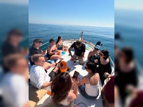 A lively group enjoys drinks and laughter aboard a yacht under the sun, perfect for celebrations and memorable outings on the water.