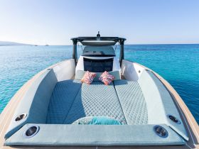 A beautifully designed lounge area on a boat, featuring plush seating and vibrant cushions, perfect for relaxing on the water.