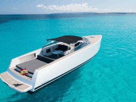 A stunning aerial view of a sleek Van Dutch yacht gliding through crystal-clear turquoise waters, perfect for luxury charters and summer adventures.