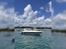 A sleek speedboat anchored in clear waters under a bright blue sky, showcasing the perfect setting for a day on the water.