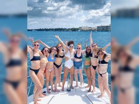 A lively group of friends celebrates on the bow of a boat, showcasing fun and camaraderie during a bachelorette party — perfect for unforgettable moments on the water.