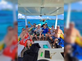 A lively group enjoys drinks and camaraderie aboard a boat, capturing the essence of a fun-filled day on the water.