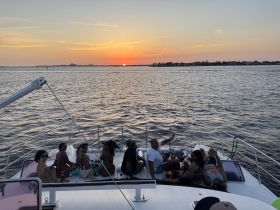 A lively group enjoys a sunset celebration aboard a yacht, capturing the essence of fun and camaraderie on the water.
