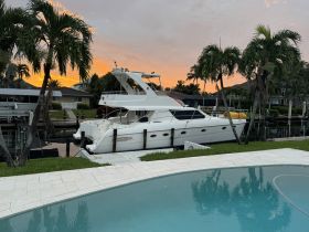 A stunning yacht docked in a serene setting, framed by palm trees and a vibrant sunset — perfect for luxury boating experiences.