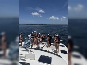 A lively group of friends enjoys a fun day on the boat, celebrating together under the sun — perfect for bachelorette parties or summer outings.