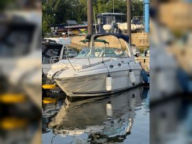 A sleek boat docked at the marina, reflecting beautifully on the calm water — perfect for leisurely outings or weekend getaways.