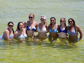 A fun group of friends enjoys a sunny day swimming together, creating unforgettable memories in the water.