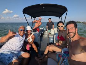 A lively group enjoys a fun day on the water, capturing smiles and good vibes aboard their boat — perfect for summer outings and celebrations.