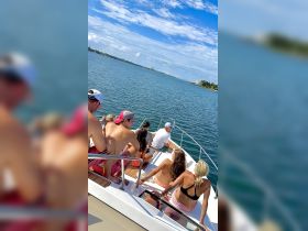 A lively group enjoys a sunny day on the water, capturing the essence of fun and relaxation aboard a boat.