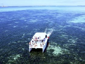 A lively group enjoys a day on the water aboard a boat, showcasing the joy of shared experiences in stunning turquoise waters.