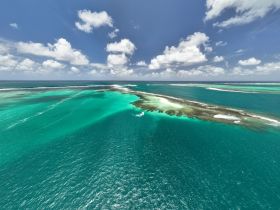 A stunning aerial view of turquoise waters and a beautiful coastline, showcasing the breathtaking scenery perfect for island hopping adventures.