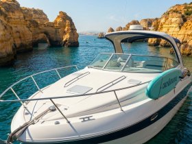 A stunning view of a yacht anchored near dramatic cliffs, showcasing the beauty of coastal waters and perfect for scenic boat tours.