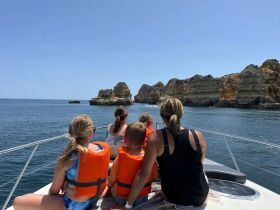 A family enjoys a scenic boat ride, taking in the stunning cliffs along the coastline — a perfect adventure for creating lasting memories on the water.