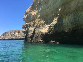 A stunning view of dramatic rock formations along the coastline, showcasing the natural beauty of the area — perfect for scenic boat tours.