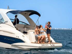 A lively group enjoys drinks on a Crownline boat, capturing the essence of fun and relaxation on the water.