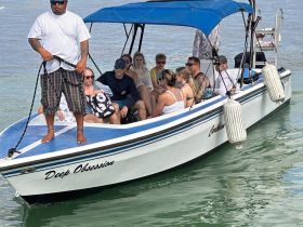 A lively group enjoys a day on the water aboard the 'Deep Obsession' boat, perfect for fun outings and adventures.