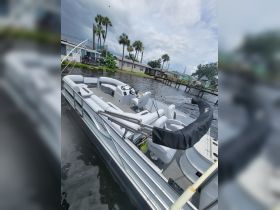 A spacious interior view of a pontoon boat featuring comfortable seating and a well-equipped helm, perfect for relaxing on the water.