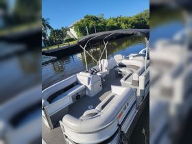 An inviting interior view of a pontoon boat featuring comfortable seating and a well-equipped helm, perfect for leisurely outings on the water.
