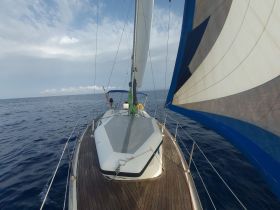 A sailboat navigates the open sea, showcasing its sleek design and vibrant sails — perfect for sailing enthusiasts and ocean adventures.