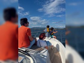 A family enjoys a scenic boat ride, taking in the beautiful views while relaxing on the deck. Perfect for creating lasting memories on the water.