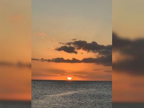 A stunning sunset over the ocean, creating a picturesque backdrop for evening boat adventures.